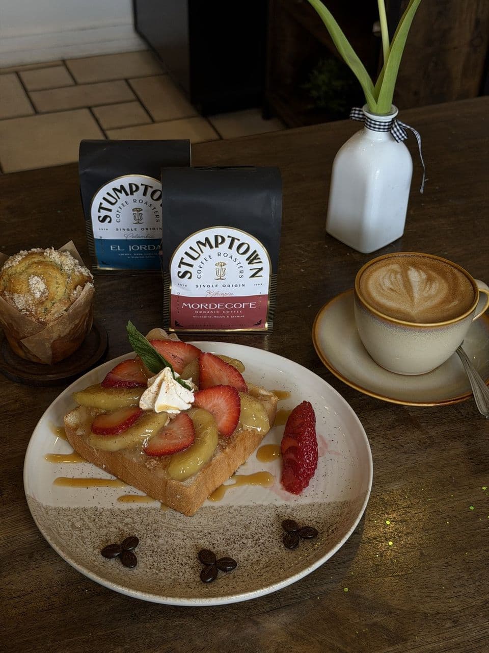 Apple Pie toast with strawberries and caramel drizzle, served with a latte and Stumptown coffee beans