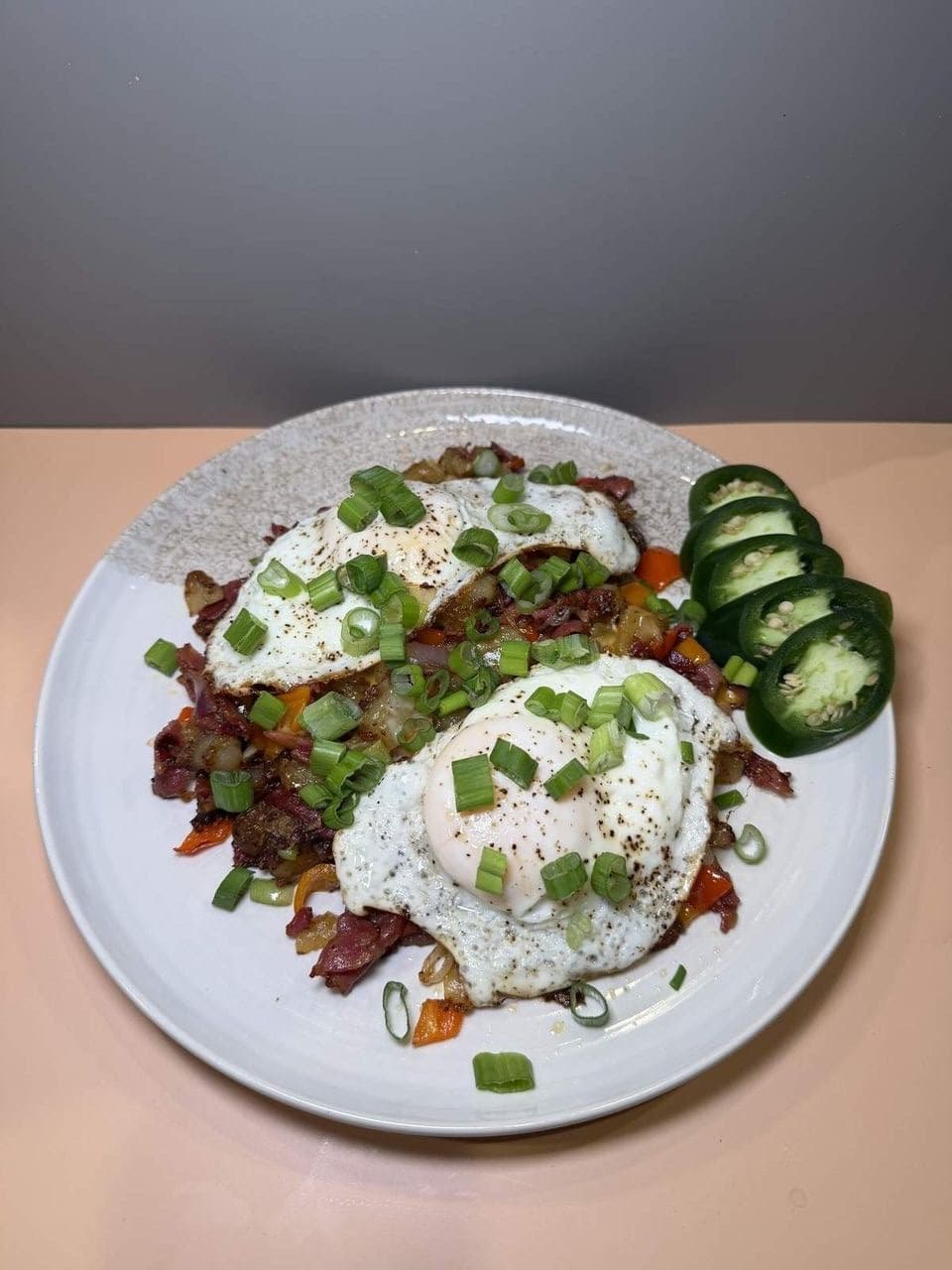 Breakfast Hash at Toasted Cafe in Montrose — Gold potatoes with red and green onion, colored bell pepper, jalapeño and house seasoning, your choice of meat, eggs and cheese.