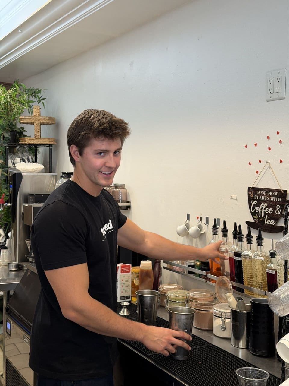 A barista at Toasted Cafe building drinks at the espresso bar with homemade syrups