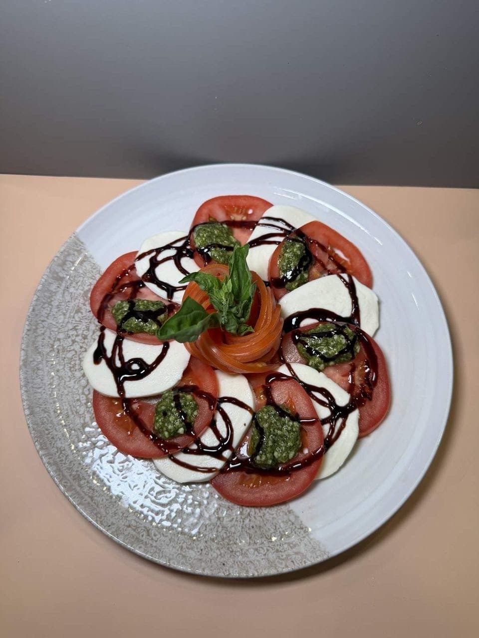 Caprese Salad at Toasted Cafe in Montrose — Tomatoes, mozzarella and basil with pesto and balsamic glaze.