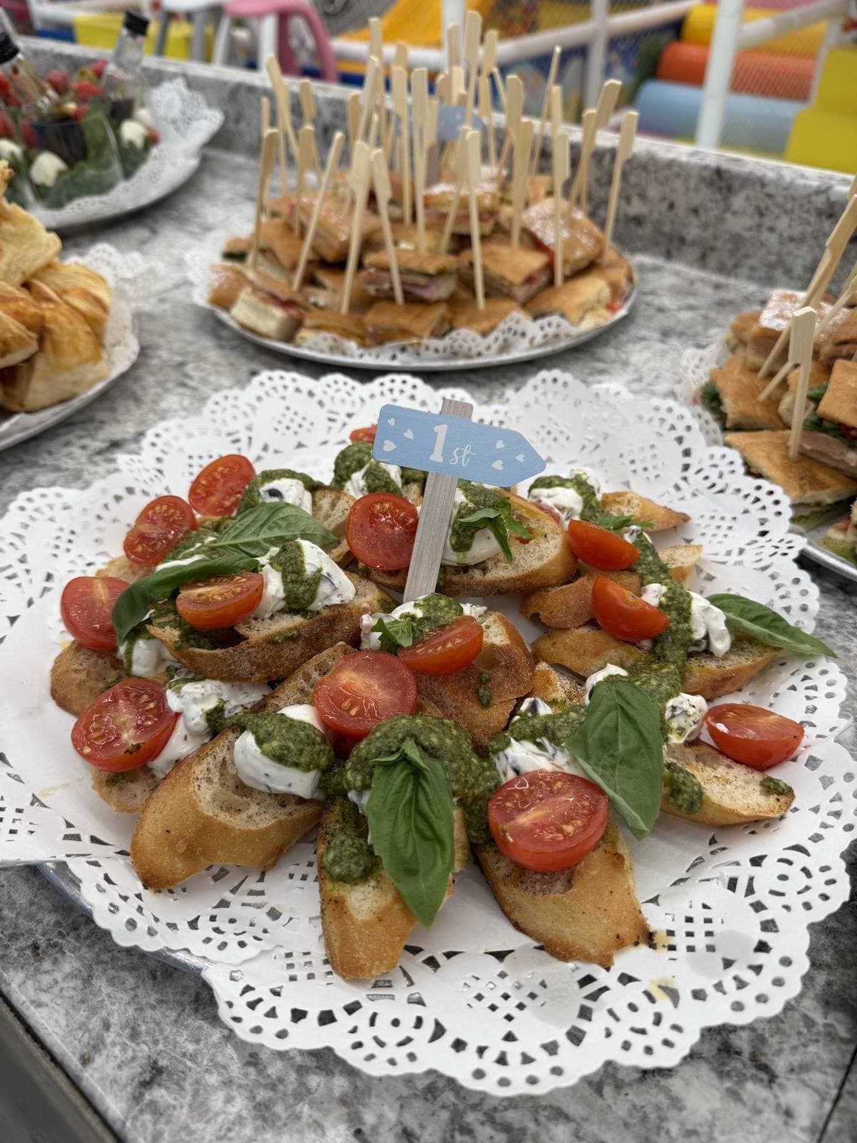 Crostini platter with mozzarella, tomato, pesto and fresh basil