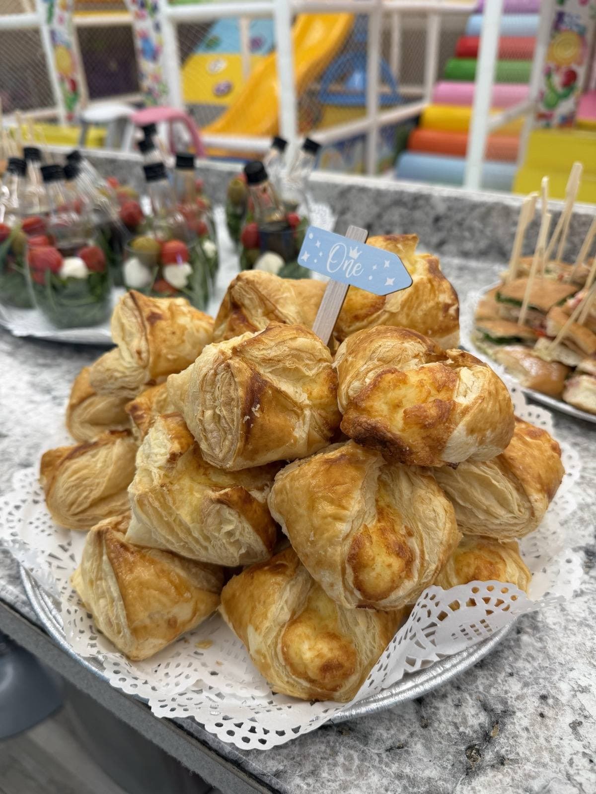 Tray of golden puff-pastry parcels on a doily-lined platter