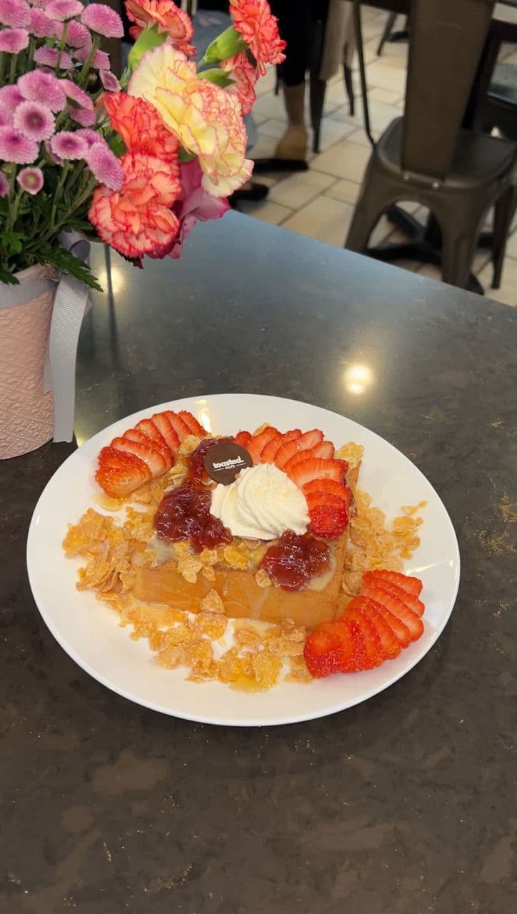 Strawberry Toast Crunch at Toasted Cafe in Montrose — Strawberry jam and strawberries under corn flakes, condensed milk, honey and whip cream.