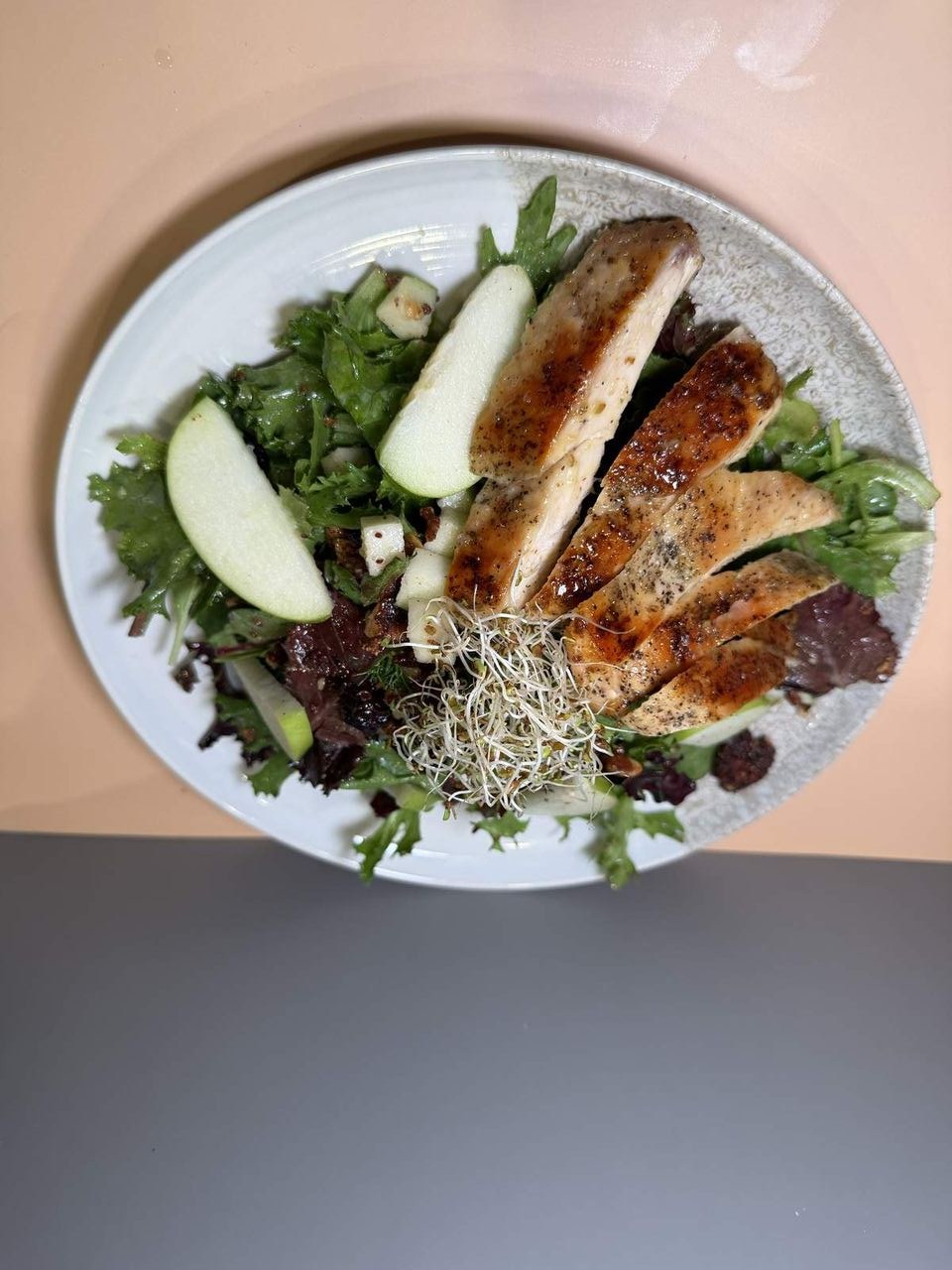 Chicken Garden Salad at Toasted Cafe in Montrose — Fresh spring mix, grilled chicken breast, crisp apple, dried cranberries, candied pumpkin seeds & pecans, alfalfa sprouts, light pear vinaigrette.