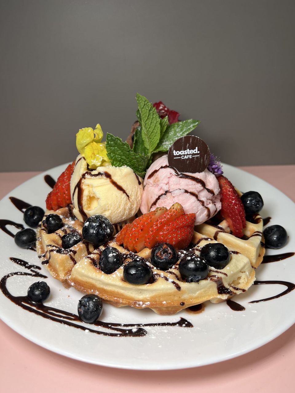 Golden Delight at Toasted Cafe in Montrose — Waffle, ice cream, strawberry, blueberry, chocolate.