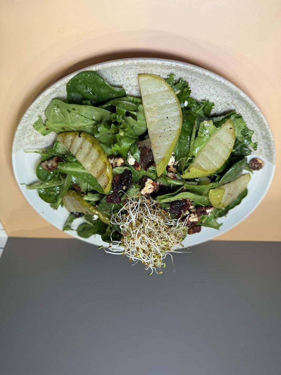 Pear & Greens Salad at Toasted Cafe in Montrose — Fresh spring mix, candied pecans and pumpkin seeds, goat cheese, caramelized pears, alfalfa sprouts, olive oil, pear vinaigrette.